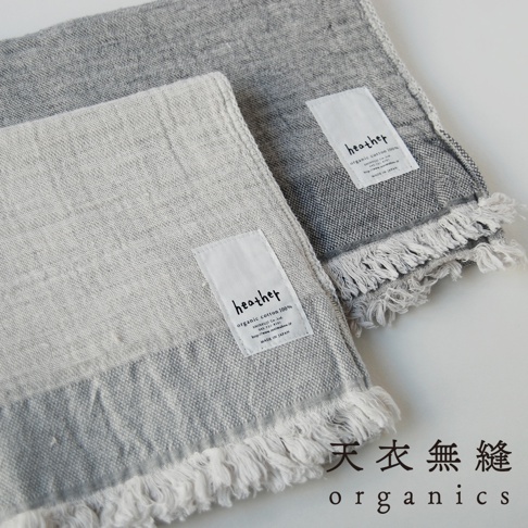 兩條 HEATHER 有機棉混紡浴巾，一條為淺灰色，另一條為深灰色，皆有流蘇邊緣和品牌標籤。