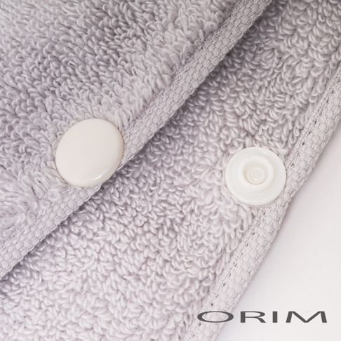 淺灰色柔軟毛巾布材質的吹髮頭巾，帶有兩個白色按扣，方便固定。