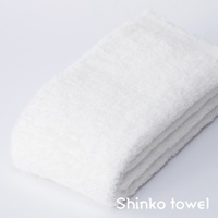 MAISON BLANC 輕奢柔膚匹馬棉浴巾，純白色，質地蓬鬆柔軟，可見細緻的織紋，疊放整齊。