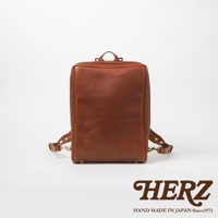 棕色皮革軟皮商務後背包，具有金屬拉鍊與扣環，展現簡約俐落的商務風格。