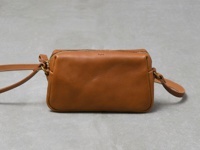 職人手作皮革Organ輕巧拉鍊單肩包，M尺寸，顏色為棕褐色，材質為皮革，包身簡潔，配有拉鍊開合和可調整的皮革背帶。