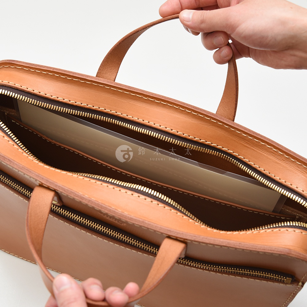 職人手作皮革兩用商務公事包，淺棕色，皮革材質，設有多個拉鍊隔層，可見手提帶和部分內襯。