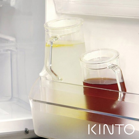 兩個透明耐熱玻璃水瓶，一個裝有檸檬水，另一個裝有深色飲料，置於冰箱架上。