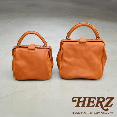 兩只棕褐色皮革手提包，風格類似醫生包，一個較小，一個較大，均配有頂部提把和金屬開口。