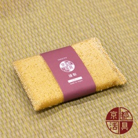 金黃色不沾鍋專用菜瓜布，表面帶有細小的顆粒紋理，由日本製造，以酒紅色包裝紙束起，包裝上印有品牌標誌和日文說明。