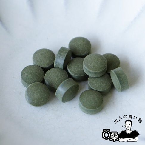 鍵庄超微粉海苔錠，堆疊在白色盤中，部分錠劑側躺，展現綠色粉末狀質地。