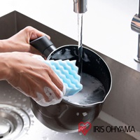 手持深棕色鑽石不沾單柄小湯鍋，用藍色海綿於水槽中清洗，鍋內有泡沫。