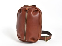 立體鞣製皮革運動斜背包，採用棕色調，配有金色拉鍊和織帶，整體設計簡潔大方。