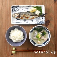 長方餐盤上盛有烤魚、檸檬片、蘿蔔泥和紫蘇葉，盤身印有藍色魚紋。旁邊是盛有白飯的灰色圓碗和盛有魚肉湯的藍白條紋圓碗。