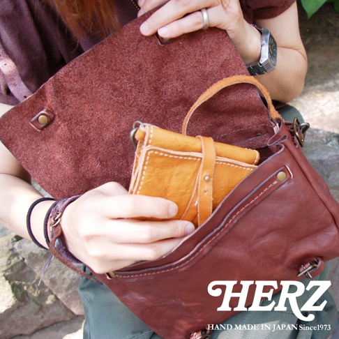 職人手作復古皮革郵差包，呈現深棕色水洗加工質感，包包內側為淺棕色皮革。