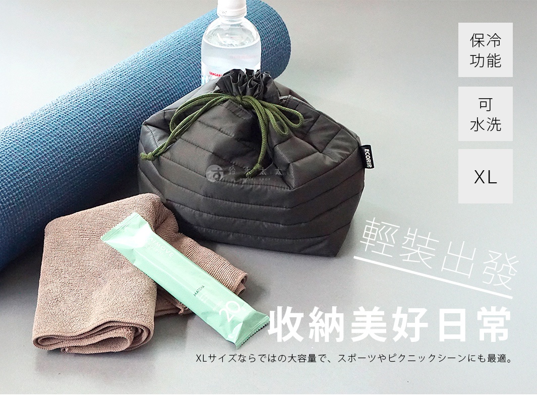 深灰色空氣感保冷束口袋平放在淺灰色檯面上，旁邊擺放著藍色瑜珈墊、折疊的棕色毛巾及綠色包裝的補給品，右側文字標示此款XL尺寸保冷袋具備保冷與可水洗功能，適合運動或野餐使用。