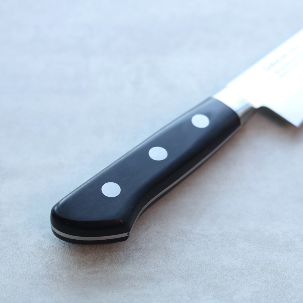 鉬釩不鏽鋼骨刻刀，特寫黑色手柄，鑲嵌三個圓形銀色铆釘，手柄與刀身連接處有銀色金屬裝飾。