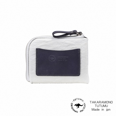TUTUMU 品牌防潑水迷你錢包，淺灰色帆布材質，前方有深藍色皮質小口袋，印有品牌標誌及 made in jpn 字樣。