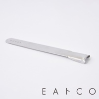 日製不鏽鋼玉米刨刀，長條狀金屬本體，一端為彎曲設計，帶有鋸齒狀邊緣，用於刨取玉米粒。