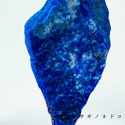一塊深藍色的青金岩礦石，表面呈現天然紋理，帶有少量白色或淺色斑點，材質為礦石。