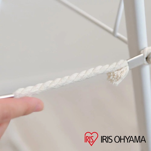 白色蝴蝶式曬衣架的細節，顯示一條白色編織繩索固定在金屬桿上，繩索末端有鬚狀處理。
