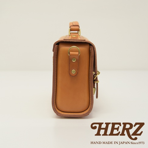 職人手作皮革極簡風兩用迷你單肩包，呈現溫潤的棕褐色調，質感紮實的皮革搭配復古金屬扣環，設計簡約實用。