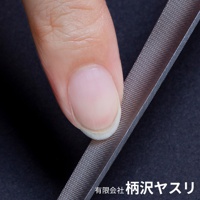 手指觸碰曲面極細高碳鋼銼刀的銀灰色表面，銼刀帶有細密的紋理。