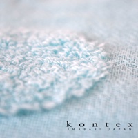 淺藍色紗布紋理特寫，一塊蓬鬆的毛巾布紋理疊加在織紋較細的紗布上，右下角有「kontex imabari japan」字樣。