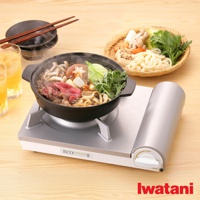 銀色節能高效瓦斯爐Eco Premium II CB-EPR-2，爐面上放置黑色鍋子，鍋內有牛肉、菇類、蔬菜、烏龍麵，冒著熱氣。旁邊有兩杯飲品、餐具及一籃食材。