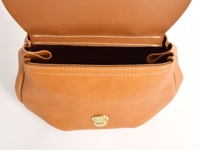 淺棕色皮革迷你後背包，頂部翻蓋開啟，露出內部空間，包身有車縫線細節，正面中央有一個金色金屬鎖扣。