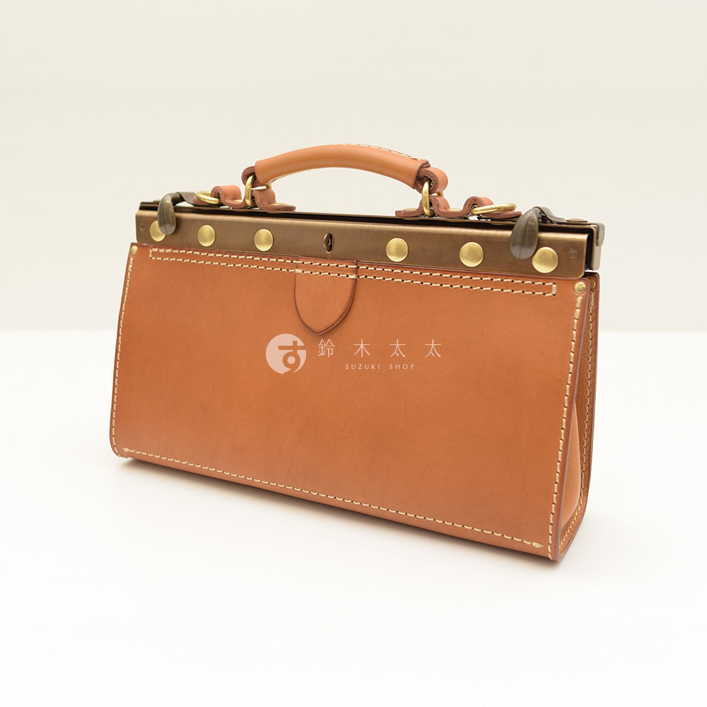 職人手作皮革復古口金兩用手提包，採用棕色皮革製成，搭配黃銅色金屬開合與鉚釘裝飾，質感細膩，設計經典。