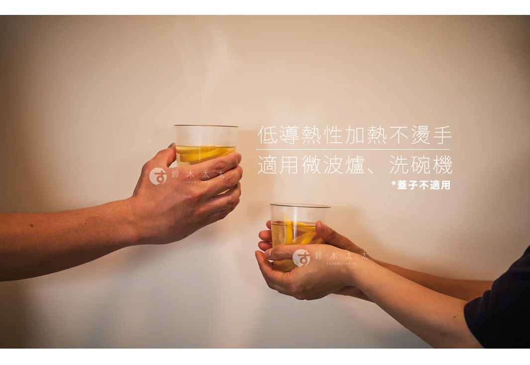 兩隻手捧著裝有檸檬片飲品的透明玻璃杯，杯身簡潔，材質為玻璃。