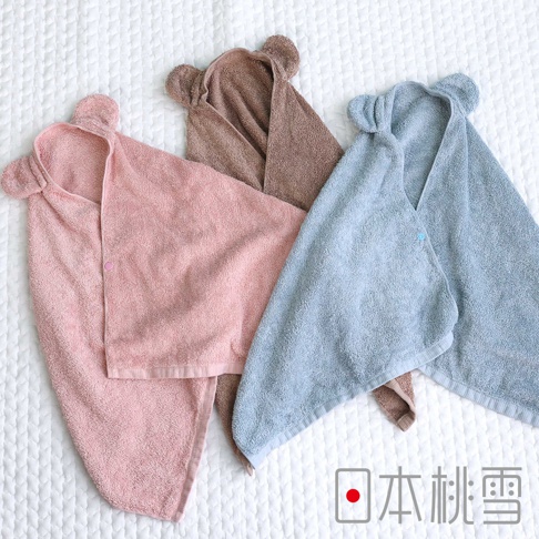 日本桃雪三色可愛熊耳連帽飯店大毛巾，粉色、咖啡色和藍色，铺在白色格紋床單上。