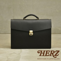 黑色皮革商務公事包，配有金屬鎖扣和頂部提把，設計簡潔大方。