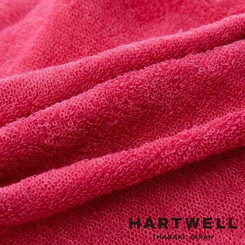 粉紅色毛巾的特寫，布料質地蓬鬆，紋理清晰，有著柔軟的觸感。