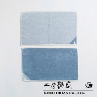 兩條棉麻混紡浴墊，一條為淺藍色，另一條為藍色，皆有白色滾邊。