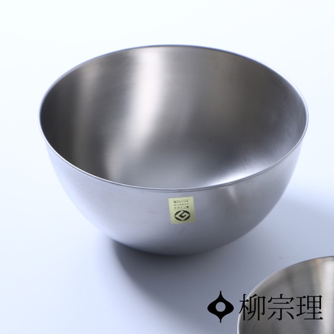 柳宗理不鏽鋼霧面調理盆，外觀呈現經典的極簡弧形設計，選用霧面髮絲紋處理的不鏽鋼材質，盆身側邊貼有標籤，整體造型流線順手，展現日式工藝的質感。