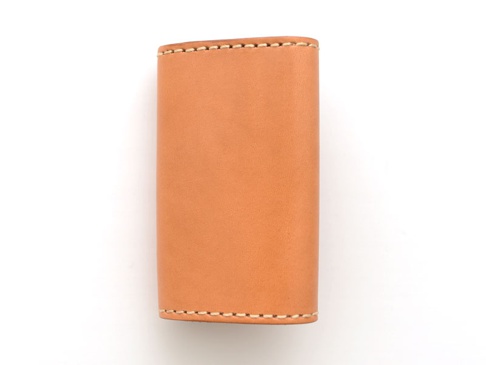 淺棕色皮革製作的經典鑰匙包，採用手工縫線，六鉤設計，簡潔實用。