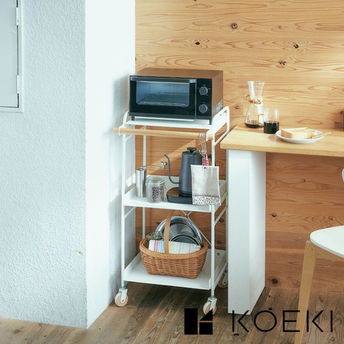 白色三層手推式置物架，頂部放置黑色烤箱，第二層有手沖咖啡壺、熱水壺、咖啡豆罐和毛巾，底部有藤編籃子和鍋子，置物架配有木製掛桿和四個輪子。