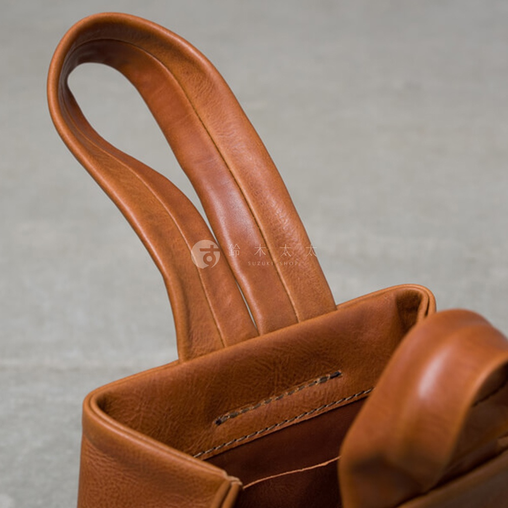職人手作皮革Organ單柄手提包，採用光滑的棕色皮革製成，具有堅固的單柄設計和精緻的縫線細節。