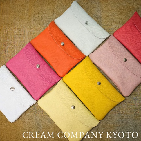 多個色彩鮮豔的皮革製多功能收納包，包括粉紅色、橙色、黃色、淺粉色、白色和紅色，皆配有銀色按扣。