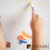 兒童手持白色畫筆在白色繪畫板上塗鴉，畫板上有黃色、橘色線條，下方有橘色、藍色磁性數字或字母，以及一個可愛的卡通造型磁鐵。