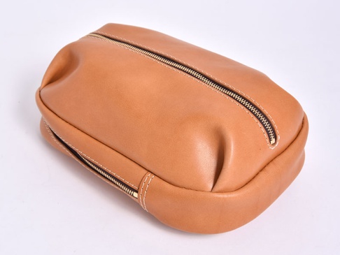 棕色皮革立體運動斜背包，頂部有拉鍊開口，側邊亦有拉鍊設計，車縫線為白色。