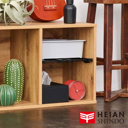 木紋層架置物架，內有白色收納盒、黑色面紙盒、紅色圓形時鐘、綠色仙人掌裝飾，上方擺放烏克麗麗和黑色瓶狀物。