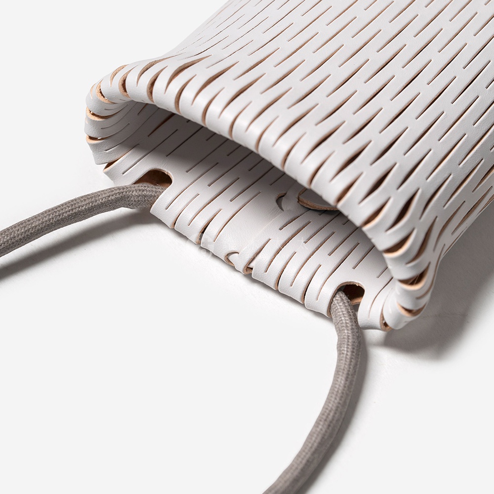 FABRIK 皮革隨形貼合伸縮小包，灰色繩帶穿過白色皮革打孔設計，細節清晰。