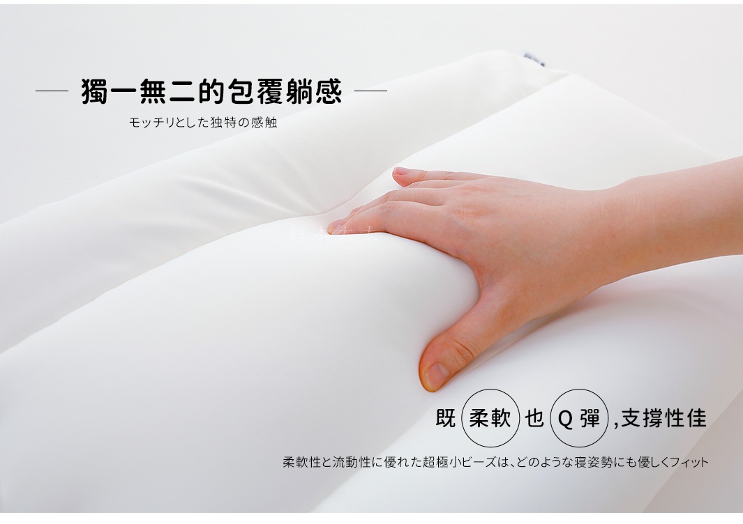 白色枕頭，由柔軟的材質製成，呈現包覆感，手部按壓在枕頭上，使其產生凹陷。