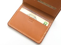 職人手作皮革雙折證件夾，呈現自然色澤的皮革材質，縫線清晰，內有卡片插槽，可收納證件。