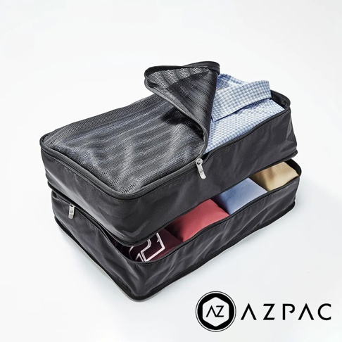 AZPAC 黑色分層旅行收納袋組，上方收納袋以網狀材質製成，內有兩件藍白格紋襯衫，下方收納袋可見粉紅色、淺藍色及卡其色衣物。