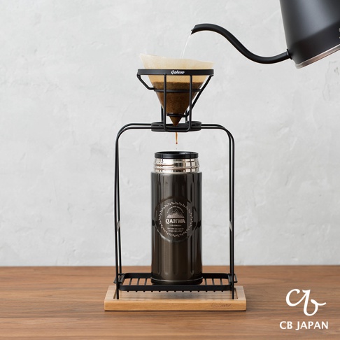 兩段式黑色金屬手沖咖啡架，搭配咖啡濾杯與咖啡壺，下方放置一個深棕色金屬保溫瓶，整體置於木質底座上。