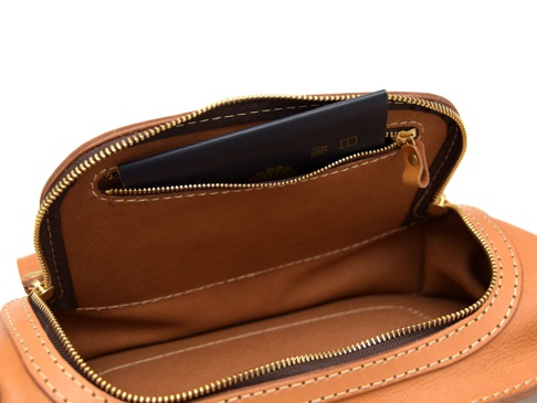 職人手作皮革拉鍊旅行斜背包 (F-7)，展現棕色皮革材質，內部有一個護照夾層，搭配金色拉鍊與縫線細節。