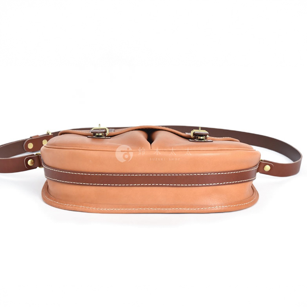 職人手作皮革傳統釣魚包，採用淺棕色皮革，搭配深棕色滾邊與縫線，設有雙扣環，附有可調節的深棕色皮革背帶。