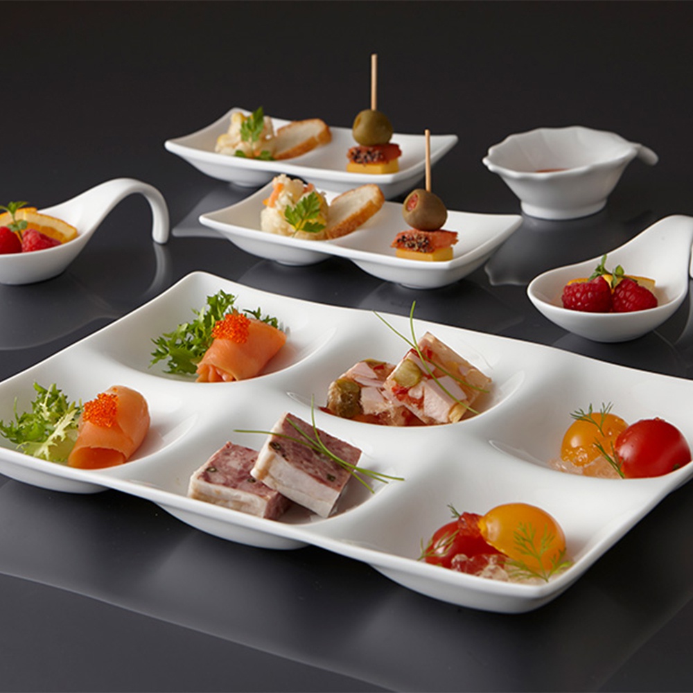 白色陶瓷六格小菜盤，盛有煙燻鮭魚、肉醬、小番茄、雞尾酒蝦、水果等精緻小點。