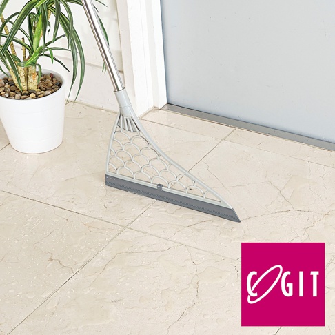 淺灰色可水洗瀝水掃帚，三角形設計，帶有魚鱗狀紋理的濾網，下方為深灰色橡膠刮條，銀色金屬掃柄，置於淺米色大理石紋瓷磚地面上。