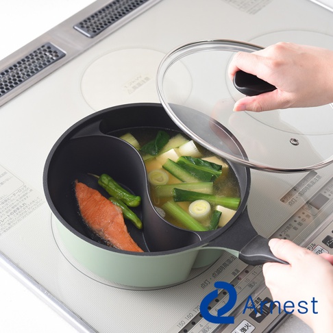 Arnest 鴛鴦鍋，左邊烹煮鮭魚和青椒，右邊燉煮湯品，玻璃鍋蓋被手扶著。