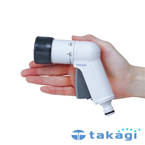 一隻手掌輕握著白色為主體的 Takagi 精巧型園藝澆花灑水槍，噴頭處為黑色橡膠材質，槍身側面標註有日文出水模式調節字樣，握把處為灰色按壓式設計，下方為水管快速連接接頭，整體外觀簡約實用。